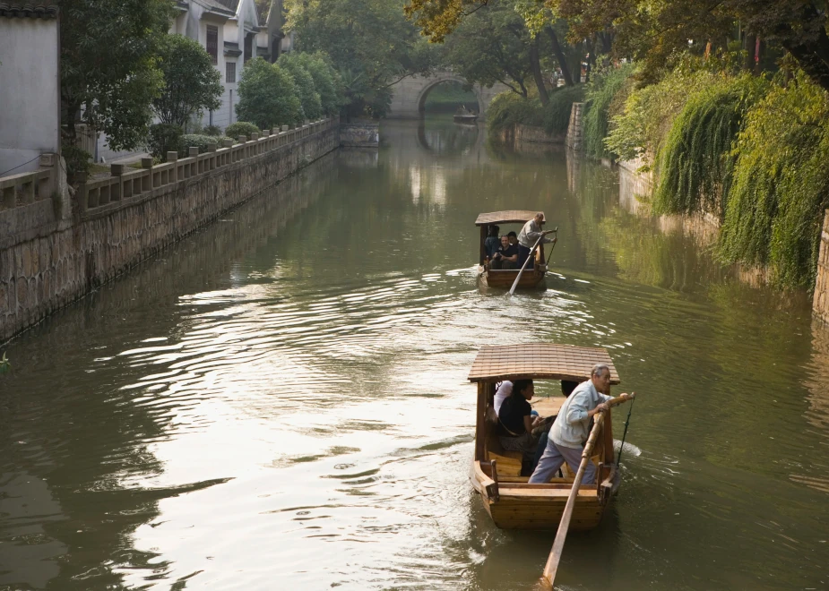 Mit einem Gondelführer auf einem Wasserkanal in Suzhou während einer Reise mit mikkoReisen